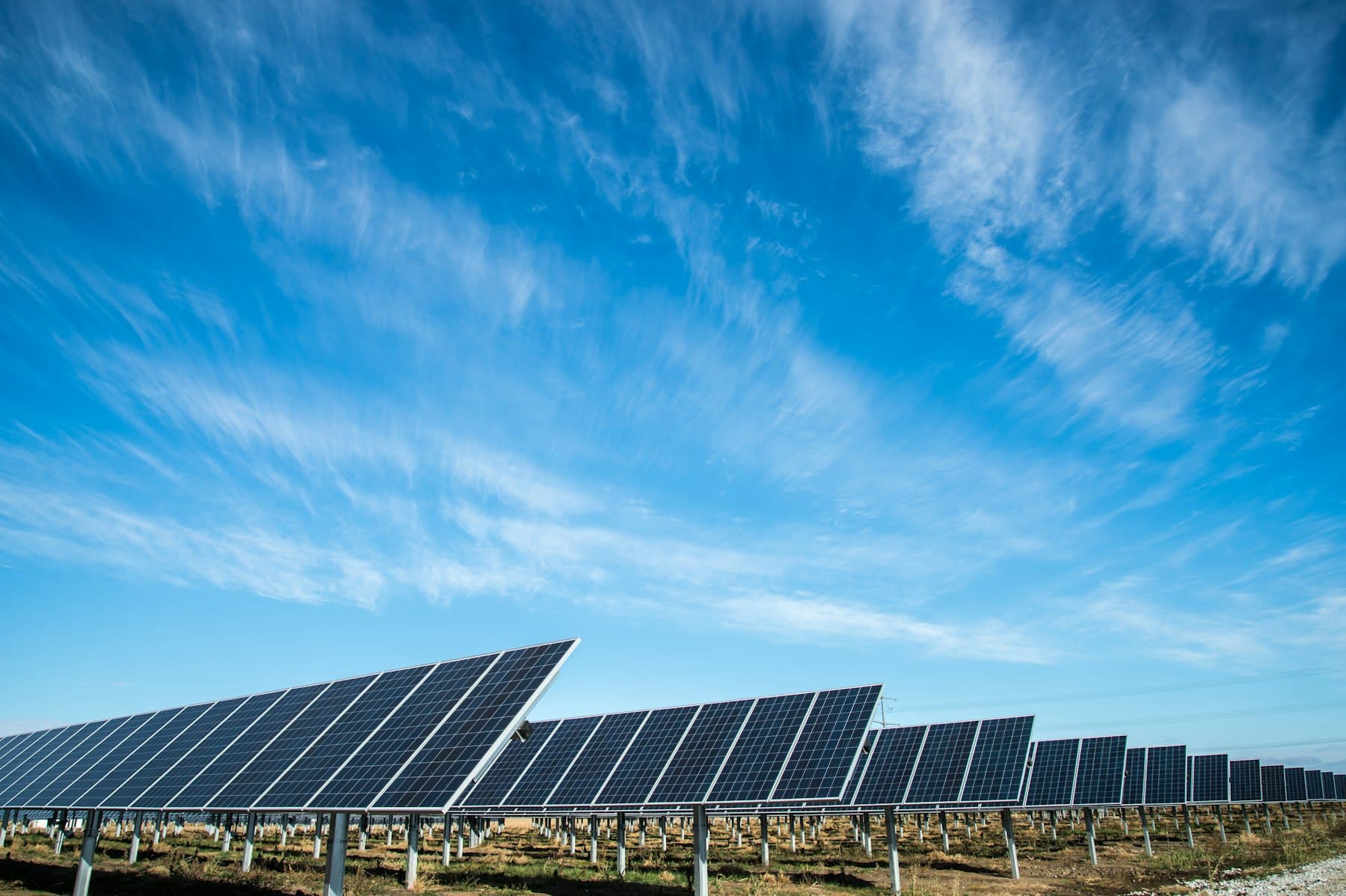 Rows of solar panels under a wide blue sky