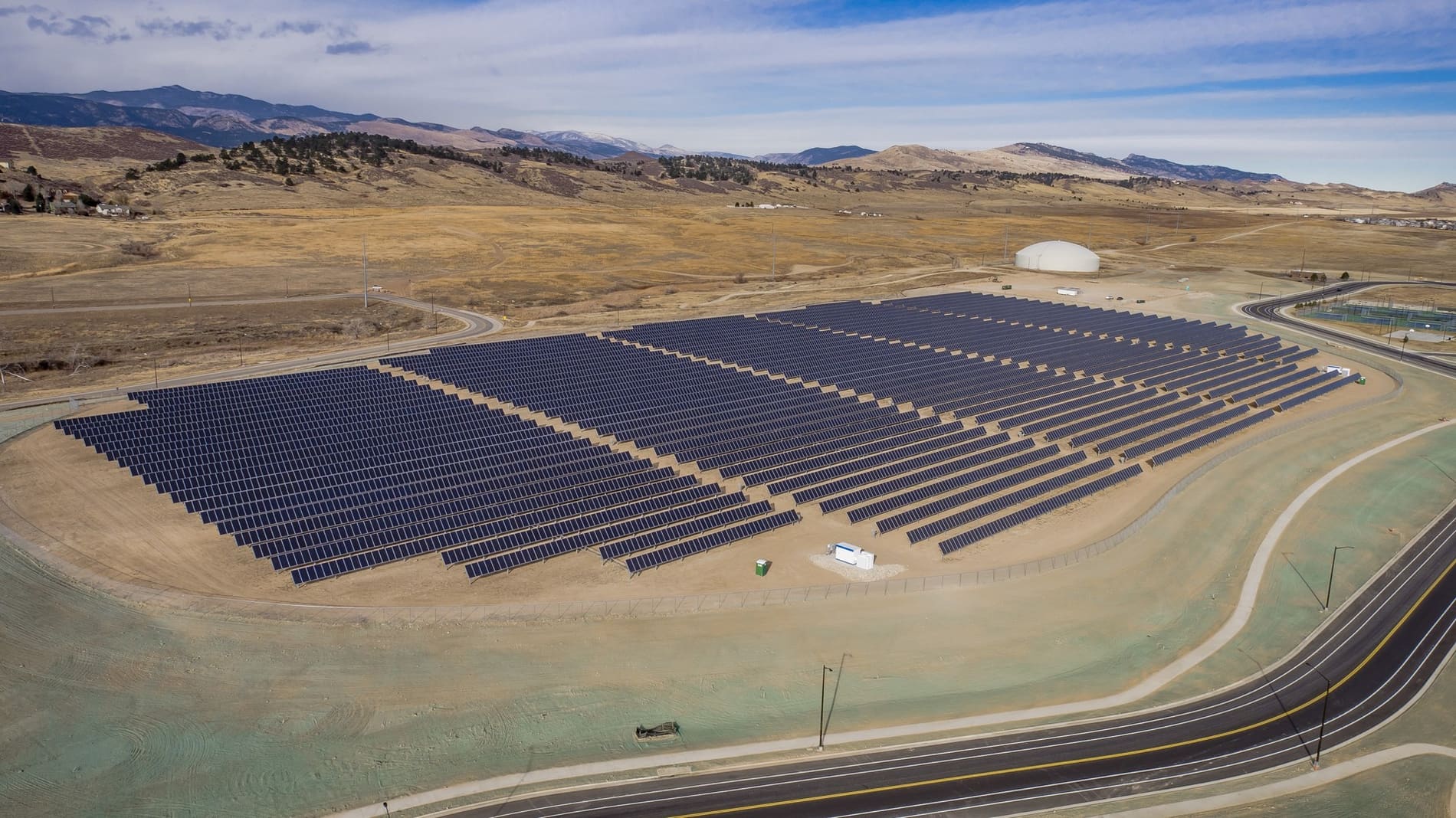 Aerial view of a complete ground-mounted solar power station in dry terrain